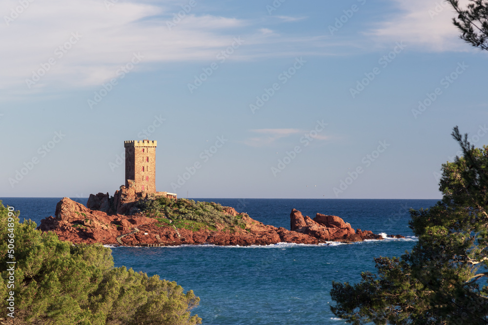 stone tower on small rocky island in the sea