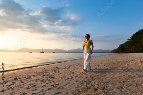 Happy Asian Woman Enjoying Beautiful Sunset on the Beach.