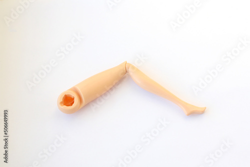 Leg from a doll. Plastic detail from Barbie doll. Broken toy.
