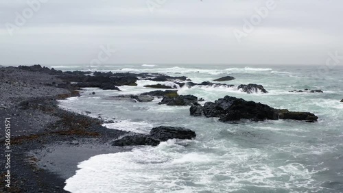 Drone show over Icelandic black sand beach showing waves in the sea. photo