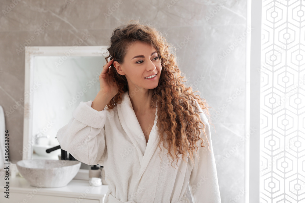 Fototapeta premium Beautiful woman wearing soft white robe in bathroom