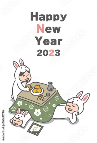 こたつでくつろぐウサギの着ぐるみを着た3人家族(2023年うさぎ年の年賀状) © michi