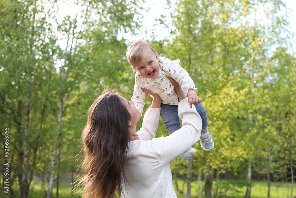 Happy mother playing with her cute baby in park on sunny day Happy mother playing with her cute baby in park on sunny day
