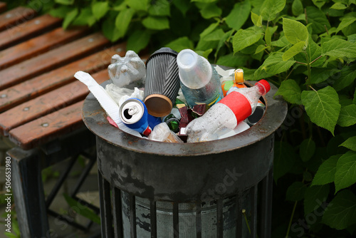 фотографія Trash bin or garbage can overflowing empty bottles