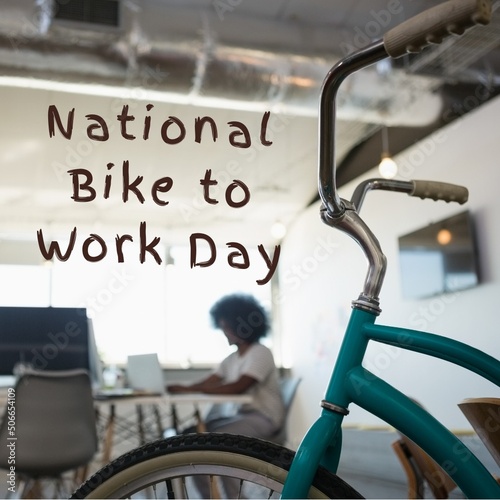 Digital composite image of bicycle with national bike to work day text in office