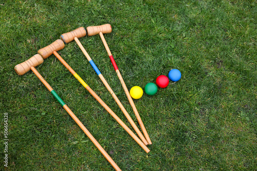 Set of croquet equipment on green grass, above view