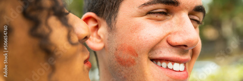 Foto Multiethnic Young people kiss on cheek with lipstick – portrait of two people ki