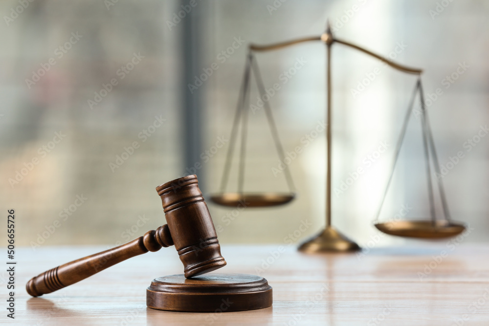 Wooden gavel and scales of justice on table indoors. Space for text Wooden gavel and scales of justice on table indoors. Space for text