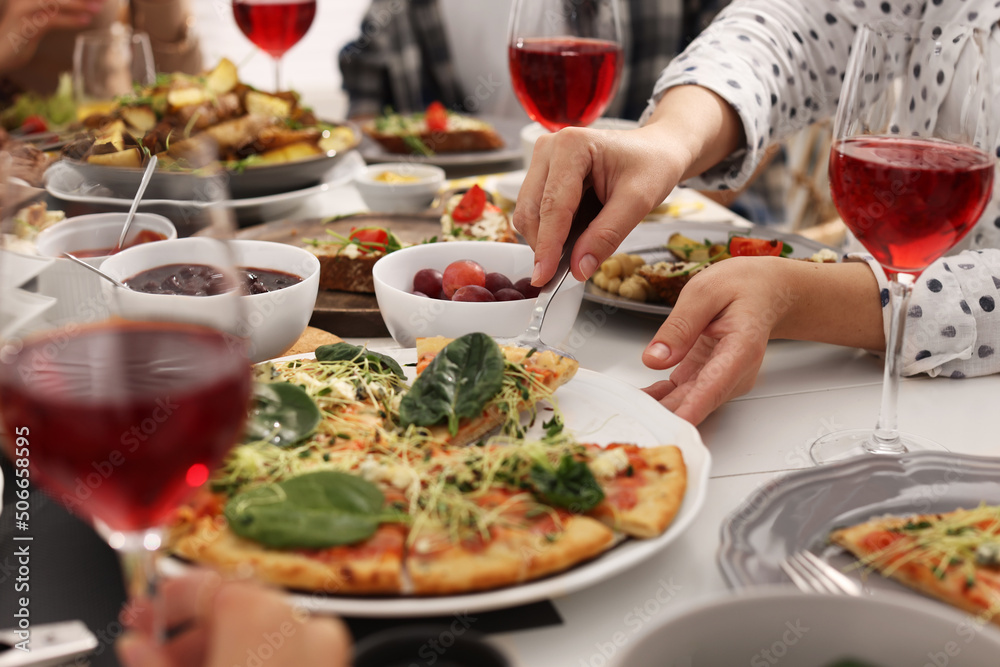Woman taking slice of pizza during brunch at table, closeup Woman taking slice of pizza during brunch at table, closeup