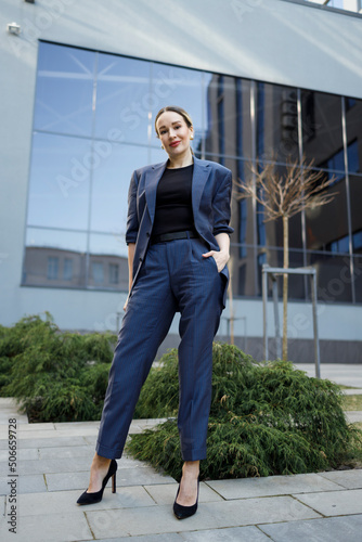 Business woman in elegance blue formal suit posing outdoors