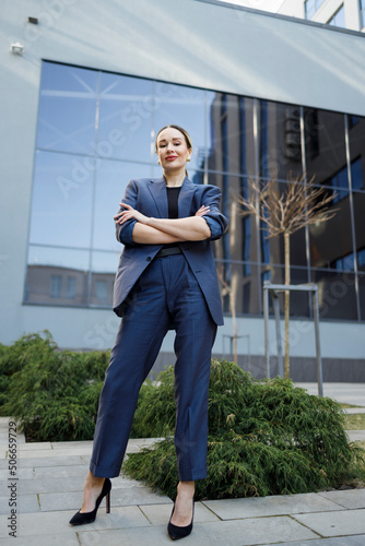 Elegant business woman with arm crossed posing outdoors