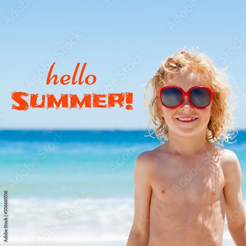 Composite of hello summer text with caucasian smiling shirtless boy wearing sunglasses at beach