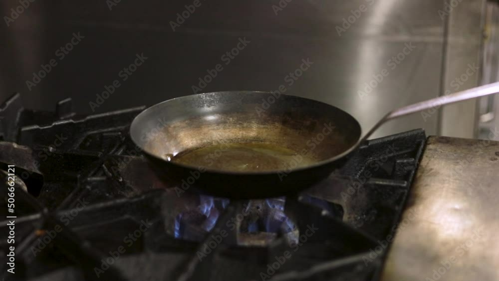 Pouring Cooking Oil In The Frying Pan Over Gas Stove. - close up Pouring Cooking Oil In The Frying Pan Over Gas Stove. - close up