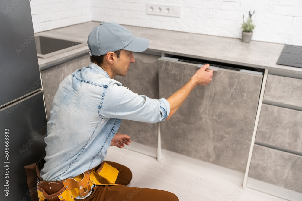 Man opening or closing dishwasher in the kitchen. Man opening or closing dishwasher in the kitchen.