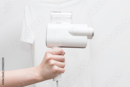 steamer for clothes on the background of a white T-shirt close-up