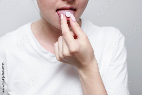 a woman with a pill on her tongue. close-up. medicine