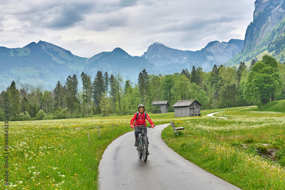 senior woman on electric mountain bike on the Bregenz Forest bicycle track up to Hochtannberg Pass, Vorarlberg, Austria
