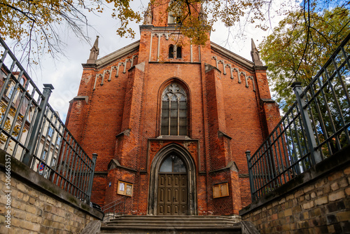 Riga, Latvia, 14 October 2021: neo-Gothic St. Saviour's church designed by Johann Felsko for English speaking congregation, Red brick, recognizable medieval landmark at old town at sunny day photo