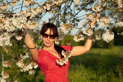 beautiful young woman next to a apple tree blooming in spring