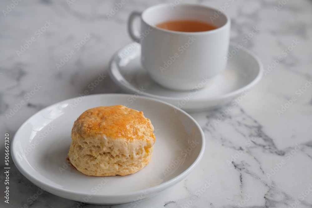Tea with scones and clotted cream, jam, strawberries on the white table Tea with scones and clotted cream, jam, strawberries on the white table