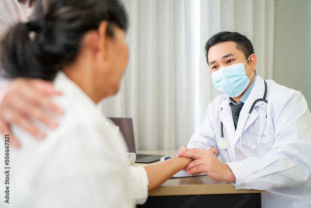 Asian male doctor wearing a mask talking to the elderly to maintain health with a smile with the concept is health care Elderly patients, adolescent doctors