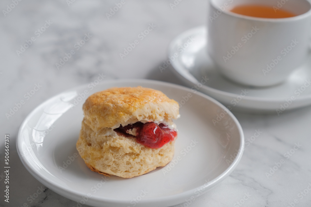 Tea with scones and clotted cream, jam, strawberries on the white table