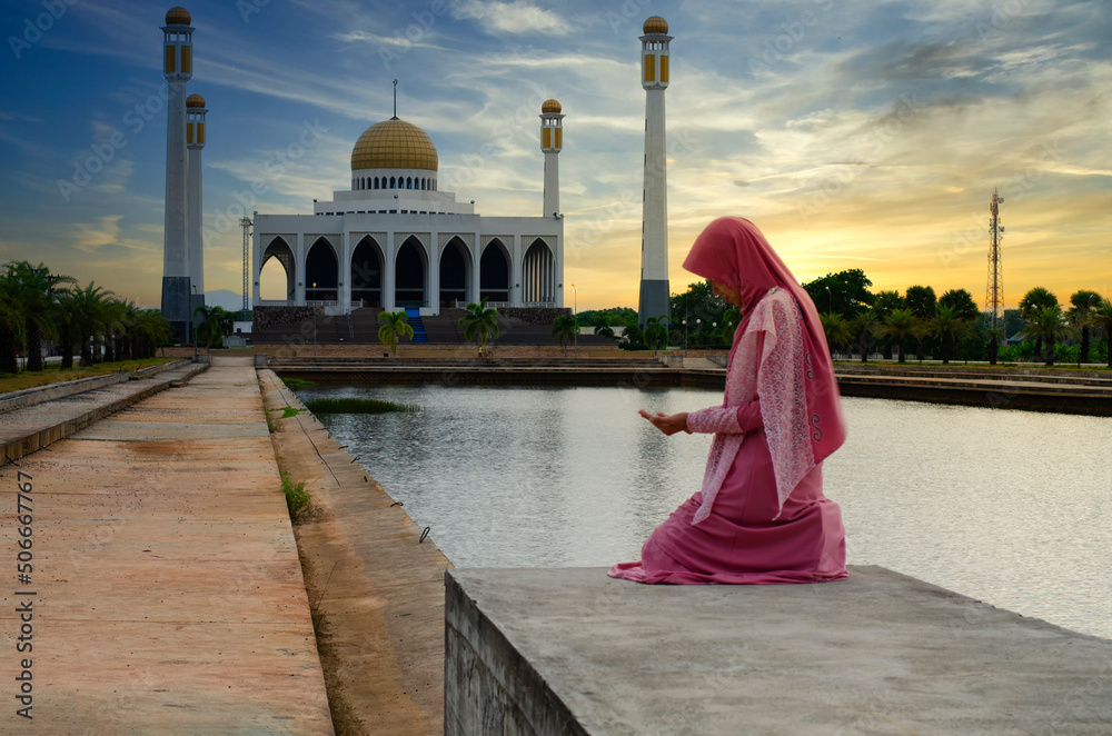 Asian Muslim woman in a veil standing and praying with Kaaba view and ...
