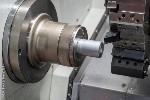 The CNC lathe machine forming cutting the metal shaft parts.