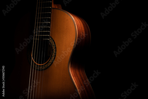 Valokuva Classical guitar close up, dramatically lit on a black background with copy space