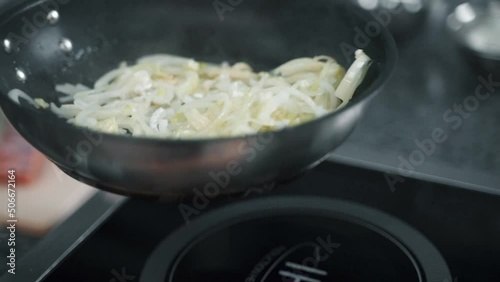 onions are fried in a frying pan in the kitchen