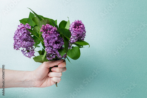 girl holding a bouquet of lilacs on a green background