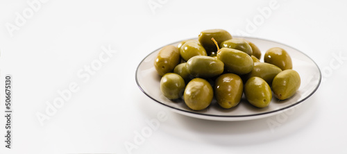 big green olives on a white plate, macro, banner, space for text