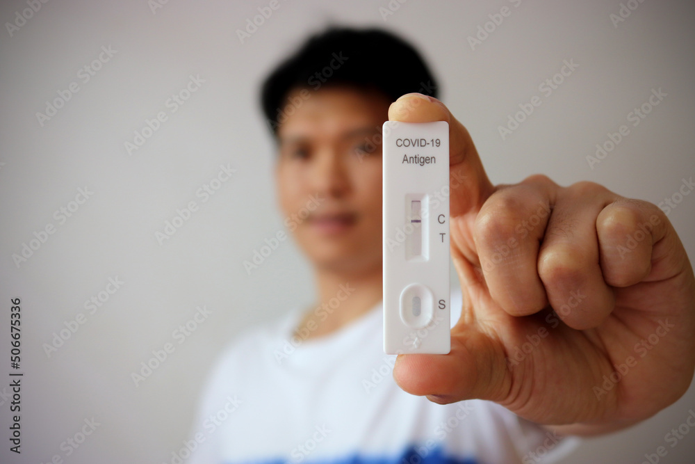 Man holding Rapid Antigen Test kit with Negative result during swab COVID-19 testing. Coronavirus Self nasal or Home test, ATK test for open the country concept. Man holding Rapid Antigen Test kit with Negative result during swab COVID-19 testing. Coronavirus Self nasal or Home test, ATK test for open the country concept.