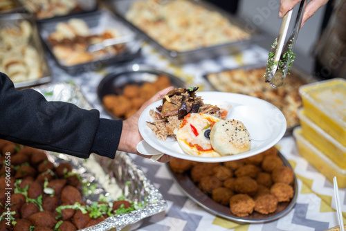 Selective focus shot of food being served on paper plate during hari raya party in Kuala Lumpur, Malaysia. 