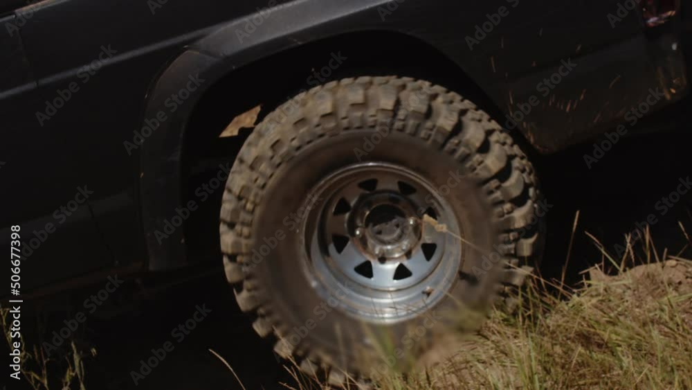 Dirty SUV is driving along off road, crushing grass under it and raising clouds of dust, side view. Car is driving on an off-road Dirty SUV is driving along off road, crushing grass under it and raising clouds of dust, side view. Car is driving on an off-road