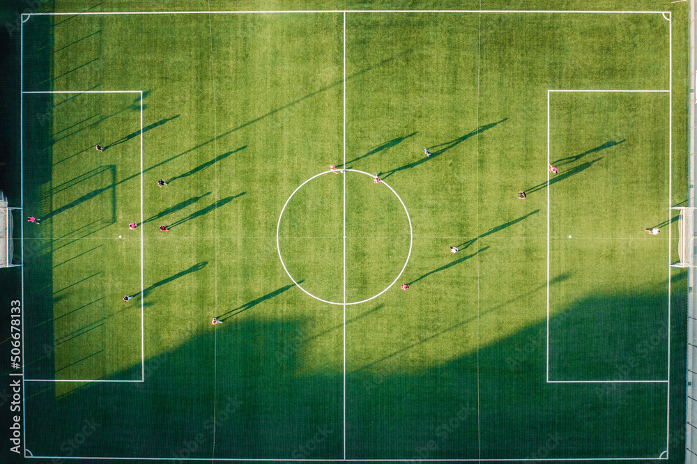 Football match on green field at sunset light - obrazy, fototapety, plakaty 