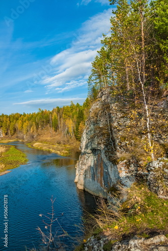 Fototapeta Naklejka Na Ścianę i Meble -  Autumn landscape with river, rock, trees, grass and blue sky