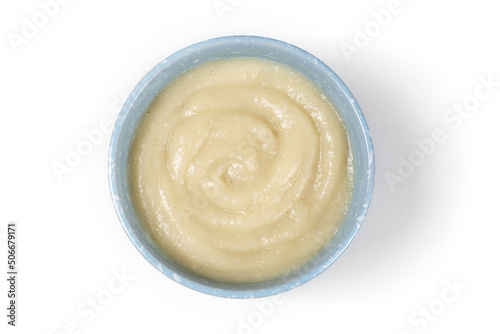 Oatmeal porridge for a baby from ground cereals in a blue bowl close-up on a white isolated background. Baby's first complementary food, baby nutrition.