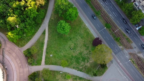 A green Flixbus on the road To Center 
Dramatic aerial view flight slowly tilt up drone footage
of Berlin Prenzlauer Berg Allee Summer 2022. Cinematic travel guide by Philipp Marnitz photo