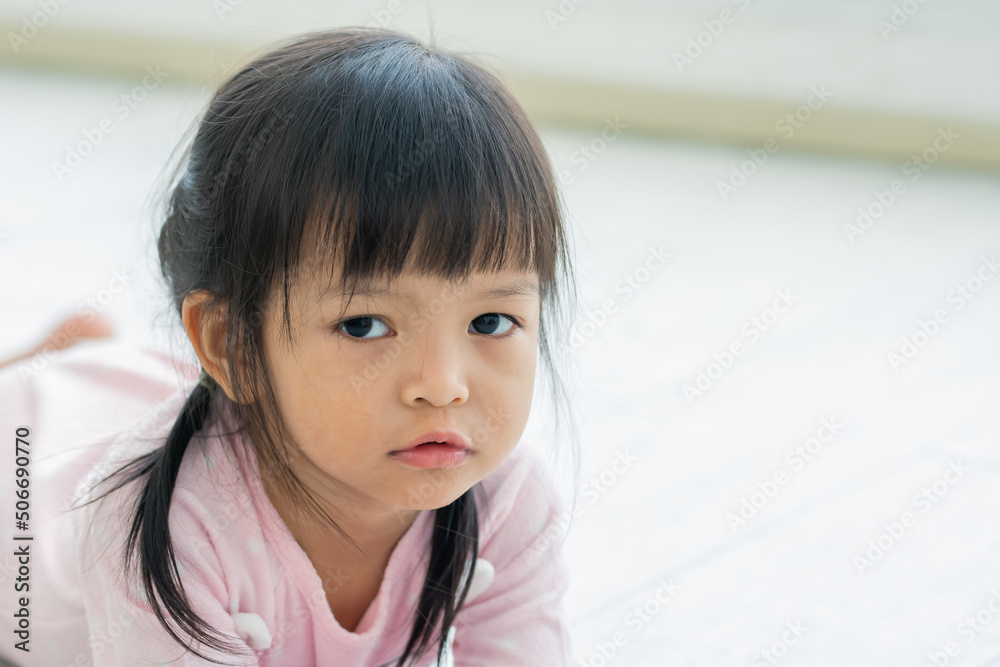 Portrait adorable Asian little daughter girl playing alone, lying down on floor in comfortable living room at home with copy space. Education, Kid Concept. Portrait adorable Asian little daughter girl playing alone, lying down on floor in comfortable living room at home with copy space. Education, Kid Concept.