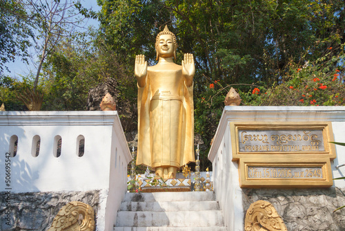 Laos - Luang Prabang - The golden standing Buddha statue in tiny Wat Tham Phousi shrine on the slopes of Phu Si hill photo