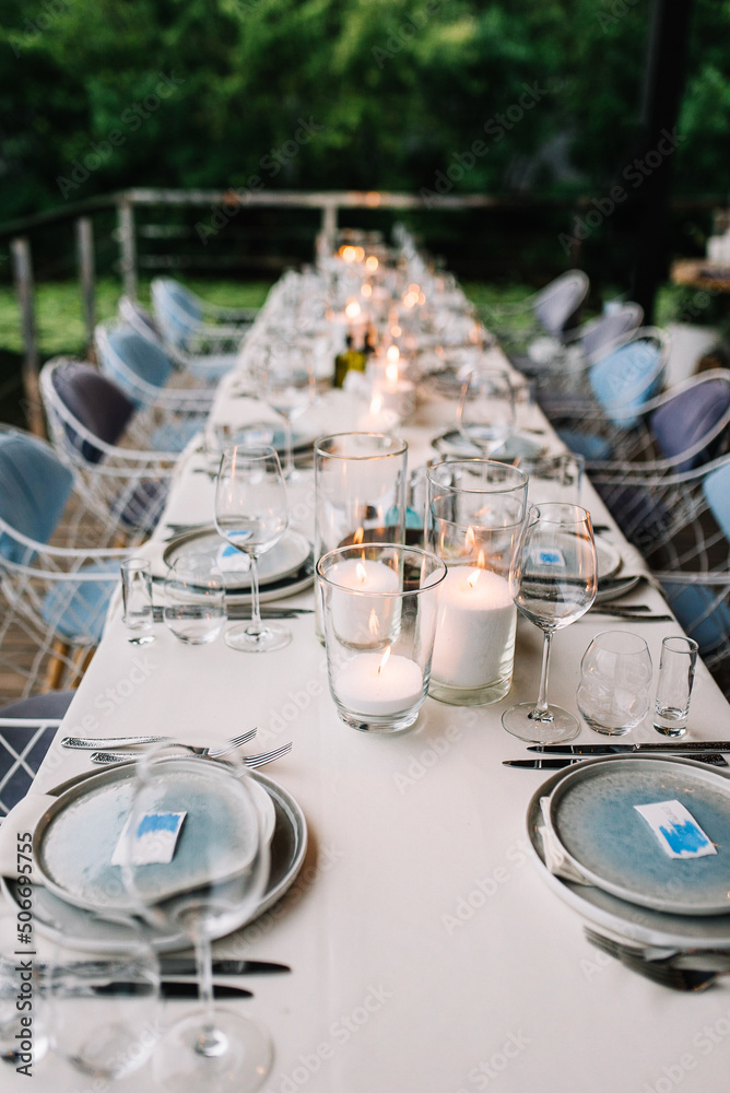Fototapeta premium Wedding table serving. Wedding banquet. Beautiful festive table decorated with bouquet of flowers, black plate with card of name guest and cutlery. Top view
