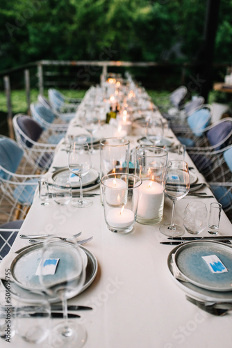 Wedding table serving. Wedding banquet. Beautiful festive table decorated with bouquet of flowers  black plate with card of name guest and cutlery. Top view