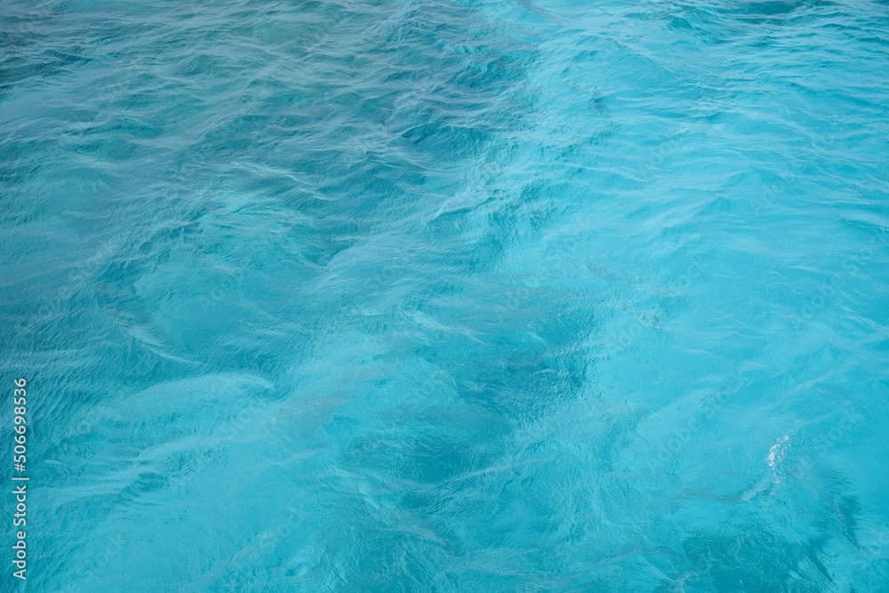 Fototapeta premium Abstract natural background, surface, texture. Waves of blue sea water. Copy space. Selective focus..