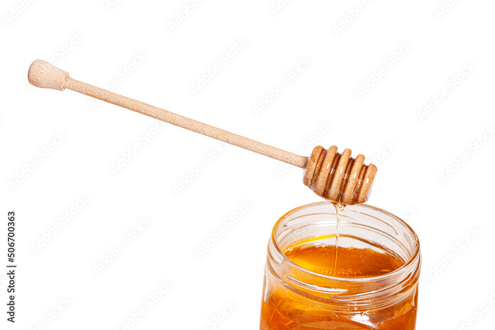 Honey dripping from honey dipper in glass jar. Healthy food concept Honey dripping from honey dipper in glass jar. Healthy food concept