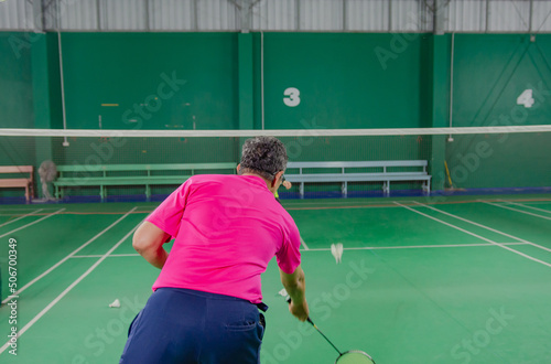 the elderly playing badminton in the badminton court The portraits are shifted and the focus is soft. © tewpai