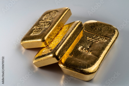 Three cast gold bars, the typical form of bullion. Selective focus.