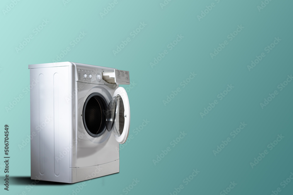 Clothes washing machine in laundry room interior on blue wall, copy space.