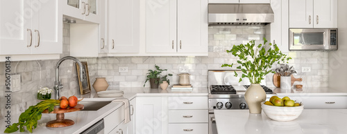Style Home Still Lifestyle Image. Contemporary Kitchen Design with White Cabinets, Counters, and Backsplash. Interior Design Social Media Banner.