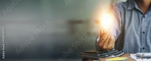 Foto Standing man hold glowing light bulb, Creative new idea